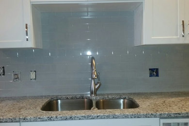 Inspiration for a mid-sized contemporary u-shaped enclosed kitchen remodel in Raleigh with an undermount sink, flat-panel cabinets, white cabinets, granite countertops, gray backsplash, ceramic backsplash, stainless steel appliances and no island