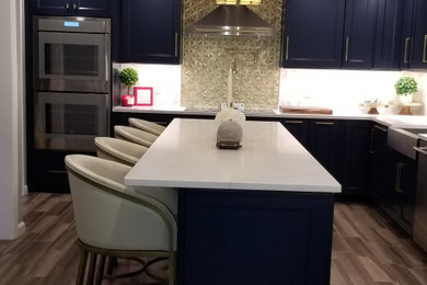 Large transitional l-shaped eat-in kitchen photo in Boston with a farmhouse sink, recessed-panel cabinets, blue cabinets, quartz countertops, multicolored backsplash, stainless steel appliances, an island and white countertops