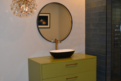 Mid-sized 1960s gray tile ceramic tile, multicolored floor and single-sink alcove shower photo in Denver with furniture-like cabinets, green cabinets, a one-piece toilet, gray walls, a vessel sink, a hinged shower door, green countertops and a freestanding vanity