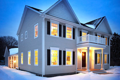 Example of a large trendy beige two-story vinyl exterior home design in New York