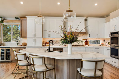 Open concept kitchen - large farmhouse l-shaped light wood floor and beige floor open concept kitchen idea in Denver with a farmhouse sink, recessed-panel cabinets, light wood cabinets, quartz countertops, white backsplash, quartz backsplash, stainless steel appliances, an island and white countertops