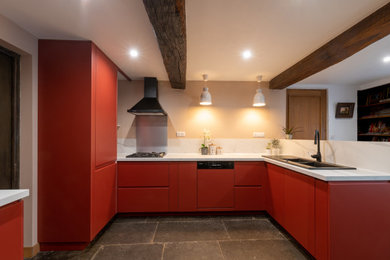Cette image montre une cuisine ouverte rustique en U avec un évier 2 bacs, un placard à porte plane, des portes de placard rouges, plan de travail en marbre, une crédence blanche, une crédence en marbre, un électroménager noir, un sol en ardoise, aucun îlot, un sol gris, un plan de travail blanc, un plafond en bois et poutres apparentes.