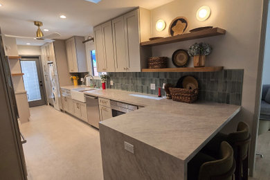 Eat-in kitchen - large modern galley porcelain tile and gray floor eat-in kitchen idea in Los Angeles with a farmhouse sink, shaker cabinets, gray cabinets, quartzite countertops, green backsplash, porcelain backsplash, stainless steel appliances, a peninsula and gray countertops