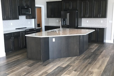 Example of a large trendy u-shaped vinyl floor and gray floor open concept kitchen design in Seattle with quartz countertops, gray backsplash, porcelain backsplash and an island