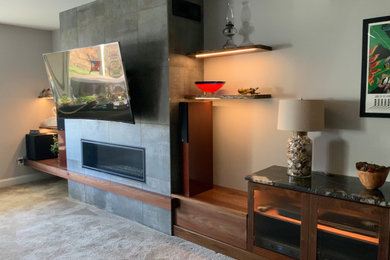 Inspiration for a medium sized modern walk-out basement in DC Metro with grey walls, carpet, a ribbon fireplace, a tiled fireplace surround and beige floors.