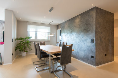 Inspiration for an expansive contemporary open plan dining in Cologne with concrete floors, beige floor and grey walls.
