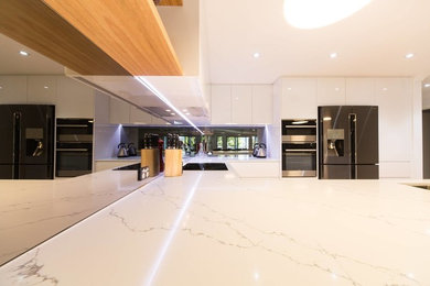 Photo of a contemporary kitchen in Newcastle - Maitland with mirror splashback.
