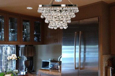 Inspiration for a mid-sized transitional kitchen remodel in Orange County with a drop-in sink, flat-panel cabinets, beige cabinets, granite countertops, stainless steel appliances and an island