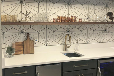Mid-sized transitional single-wall carpeted wet bar photo in Denver with shaker cabinets, gray cabinets, quartz countertops, white backsplash, porcelain backsplash and white countertops