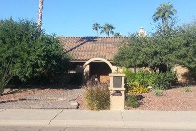 Example of a mid-sized southwest beige one-story house exterior design in Phoenix with a clipped gable roof and a tile roof