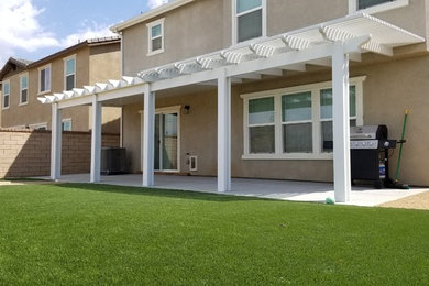 This is an example of a mid-sized traditional drought-tolerant and partial sun backyard landscaping in Los Angeles with decking.