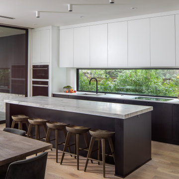 Modern Kitchen with Mitered Stone Island, Streamlined Cabinetry & Furnished Seat