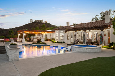 Pool landscaping - large mediterranean backyard concrete and custom-shaped pool landscaping idea in San Diego
