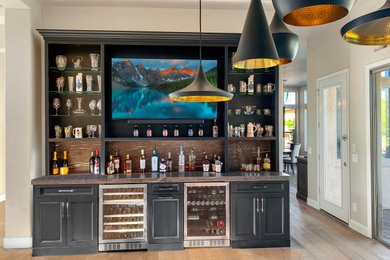 Foto de bar en casa tradicional con armarios con paneles empotrados, encimera de granito, puertas de granito, suelo de madera en tonos medios y encimeras marrones