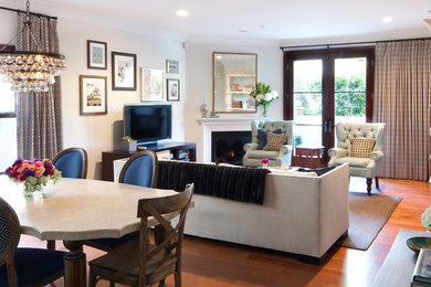 Example of a mid-sized transitional open concept medium tone wood floor and brown floor family room design in Los Angeles with a bar, white walls, a standard fireplace, a metal fireplace and a tv stand