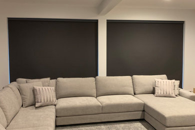 Mid-sized contemporary open concept home theatre in Melbourne with white walls, carpet and multi-coloured floor.