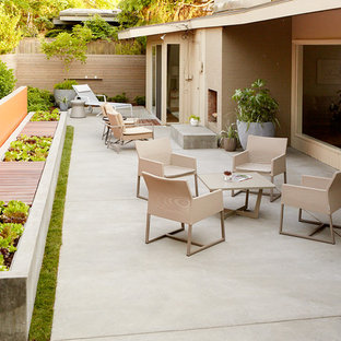 Photo of a midcentury patio in Seattle with a fire feature, concrete slab and no cover.