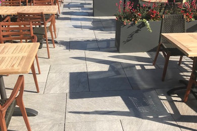 Patio - large modern backyard tile patio idea in Minneapolis