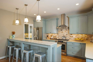 Inspiration for a large transitional l-shaped eat-in kitchen in Baltimore with recessed-panel cabinets, blue cabinets, granite benchtops, beige splashback, stone tile splashback, stainless steel appliances, light hardwood floors and with island.