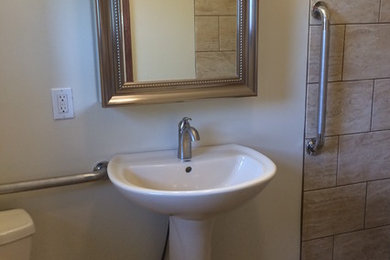 Small elegant 3/4 beige tile, brown tile and porcelain tile medium tone wood floor and brown floor bathroom photo in St Louis with a two-piece toilet, white walls and a pedestal sink