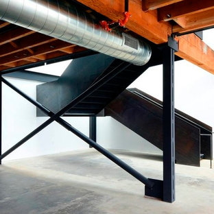 Photo of a large industrial metal u-shaped metal railing staircase in Seattle with metal risers.