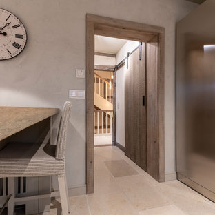 Large farmhouse kitchen pantry designs - Example of a large cottage single-wall limestone floor and beige floor kitchen pantry design in Frankfurt with a double-bowl sink, beaded inset cabinets, gray cabinets, gray backsplash, an island and gray countertops