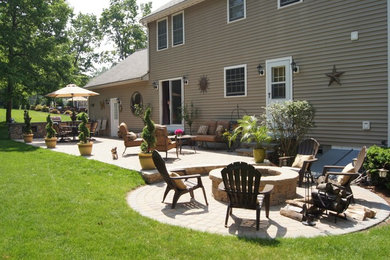Backyard brick patio photo in Boston with a fire pit and no cover