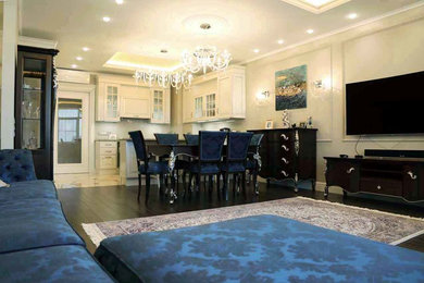 На фото: открытая гостиная комната среднего размера в классическом стиле с бежевыми стенами, темным паркетным полом и телевизором на стене