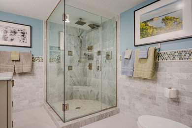 Corner shower - mid-sized transitional 3/4 subway tile porcelain tile corner shower idea in Chicago with recessed-panel cabinets, white cabinets, a two-piece toilet, blue walls, a console sink and solid surface countertops