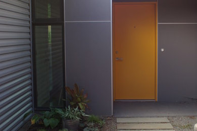 Inspiration for a modern entryway in Denver with grey walls, a single front door and an orange front door.