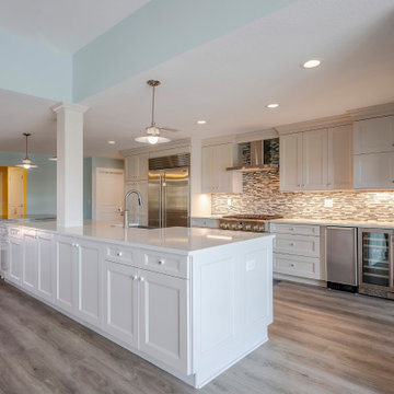 Bright Transitional Kitchen With Oversized Island and Stainless Built-In Refrige