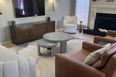 Example of a mid-sized trendy light wood floor and wall paneling living room design in Oklahoma City with gray walls, a standard fireplace, a wood fireplace surround and a wall-mounted tv