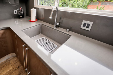 Inspiration for a large modern l-shaped enclosed kitchen remodel in San Francisco with quartz countertops and gray backsplash