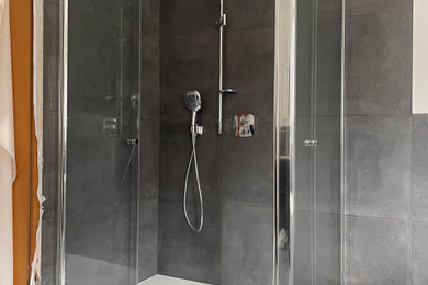 Mittelgroßes Modernes Duschbad mit Eckdusche, schwarzen Fliesen, Porzellanfliesen, schwarzer Wandfarbe, Porzellan-Bodenfliesen, schwarzem Boden und Falttür-Duschabtrennung in Sonstige