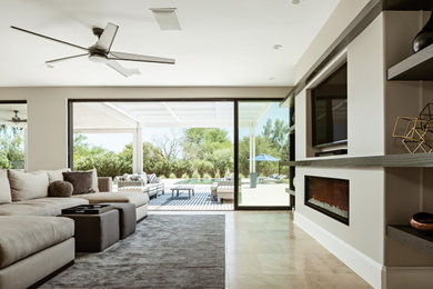 Family room - large contemporary travertine floor family room idea in Phoenix with gray walls, a standard fireplace, a plaster fireplace and a media wall