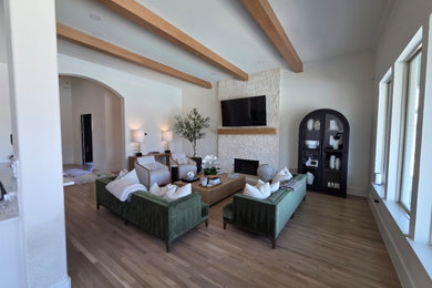 Inspiration for a light wood floor and exposed beam living room remodel in Dallas with white walls, a standard fireplace and a stone fireplace