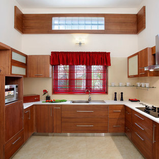 Immagine di una cucina ad U etnica con lavello da incasso, ante lisce, ante in legno scuro, paraspruzzi beige, nessuna isola, pavimento beige e top bianco