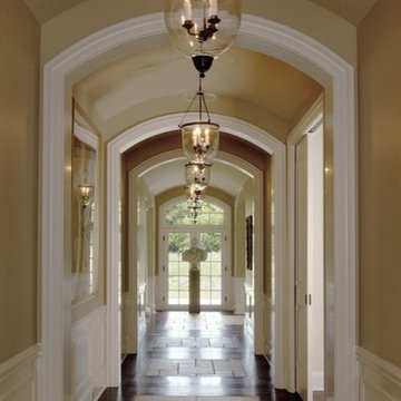 Hallway featuring Arched Openings, Wainscot, Limestone and Dark Hardwood