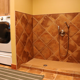 他の地域の中サイズのラスティックスタイルのおしゃれな家事室 (ドロップインシンク、トラバーチンの床、左右配置の洗濯機・乾燥機、オレンジの壁) の写真