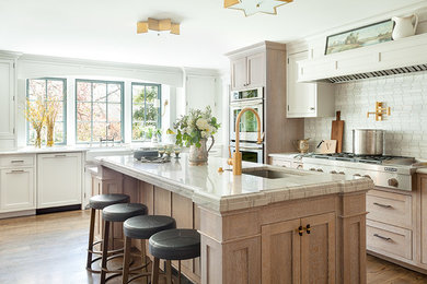 Kitchen - transitional medium tone wood floor and brown floor kitchen idea in New York with an undermount sink, beaded inset cabinets, light wood cabinets, white backsplash, stone tile backsplash, stainless steel appliances, an island, white countertops and quartzite countertops