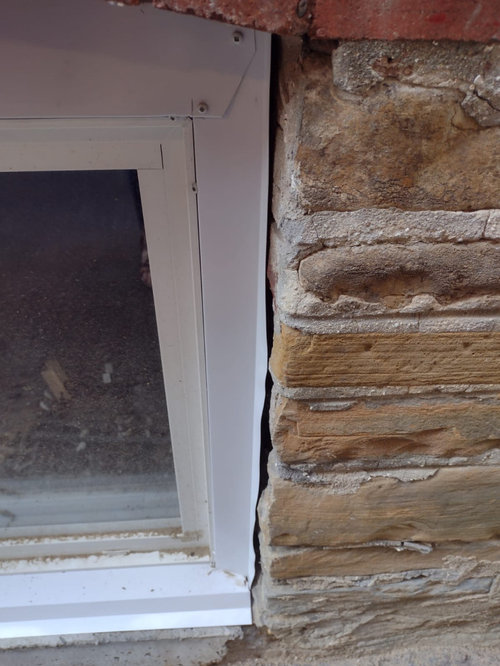 Gap between aluminum window trim and bricks.