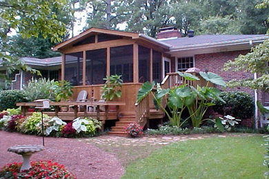 Inspiration for a mid-sized screened-in back porch remodel in Raleigh with decking and a roof extension