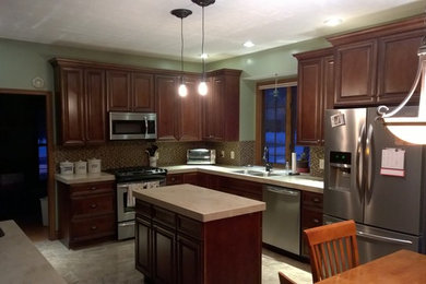 Eat-in kitchen - mid-sized traditional l-shaped porcelain tile eat-in kitchen idea in Other with a double-bowl sink, raised-panel cabinets, dark wood cabinets, quartz countertops, multicolored backsplash, mosaic tile backsplash, stainless steel appliances and an island