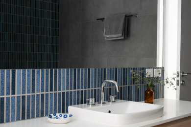 Стильный дизайн: маленькая ванная комната в современном стиле с фасадами цвета дерева среднего тона, угловым душем, инсталляцией, синей плиткой, керамической плиткой, белыми стенами, бетонным полом, врезной раковиной, серым полом, открытым душем, белой столешницей, тумбой под одну раковину и подвесной тумбой для на участке и в саду - последний тренд