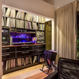 This is an example of a midcentury open plan home cinema in Las Vegas with white walls, bamboo flooring and brown floors.