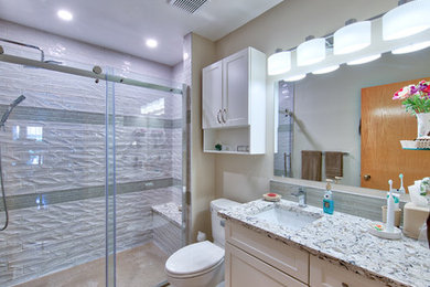 Inspiration for a small transitional bathroom in Edmonton with shaker cabinets, white cabinets, an alcove shower, a two-piece toilet, white tile, blue tile, ceramic tile, an undermount sink, grey floor, a sliding shower screen, beige walls, concrete floors, granite benchtops and multi-coloured benchtops.