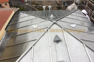 Modelo de fachada de piso beige y gris contemporánea pequeña de dos plantas con revestimiento de hormigón, tejado a cuatro aguas y tejado de metal