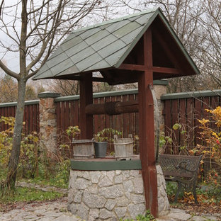 Immagine di un giardino country dietro casa con fontane e pavimentazioni in pietra naturale