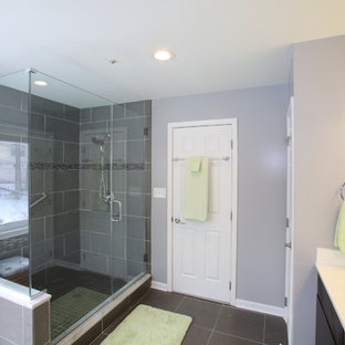 Esempio di una grande stanza da bagno padronale moderna con ante lisce, ante in legno bruno, vasca ad angolo, WC monopezzo, pareti grigie, lavabo integrato, top in granito, doccia ad angolo, piastrelle grigie, piastrelle in ceramica, pavimento con piastrelle in ceramica, pavimento grigio e porta doccia a battente