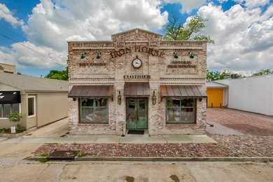 Mid-sized rustic beige brick flat roof idea in New Orleans